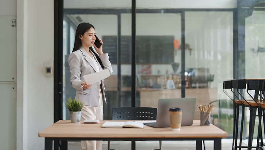 Realtor talking to client on phone in modern office